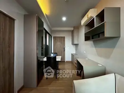Modern apartment interior with sleek furniture and wooden flooring, featuring a dining area and air conditioning.