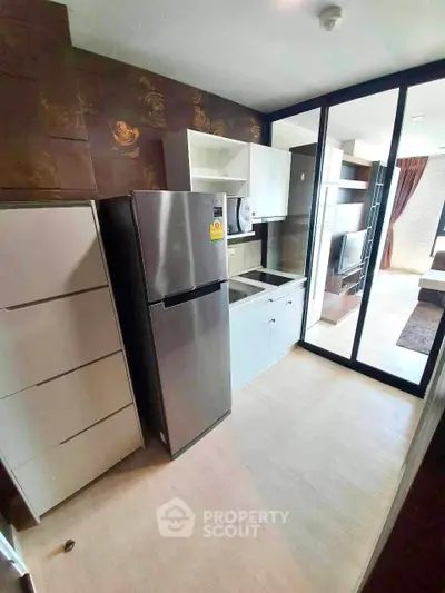 Modern kitchen with stainless steel fridge and open layout in stylish apartment