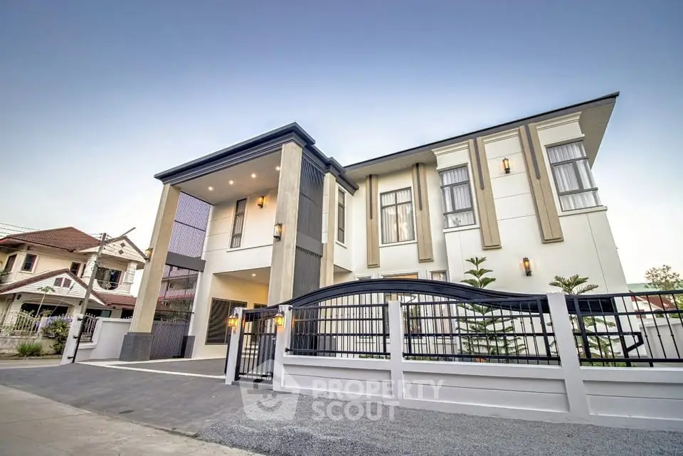 Stunning modern two-story house with elegant facade and gated entrance in a serene neighborhood.