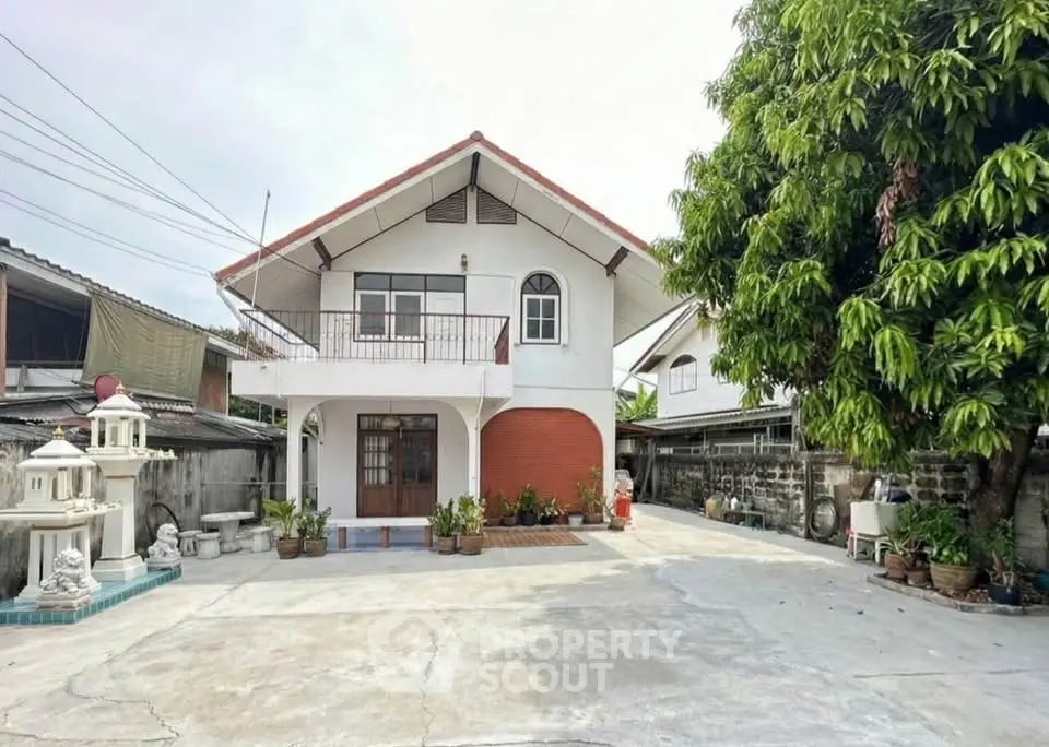 Charming two-story house with spacious driveway and lush greenery, perfect for family living.