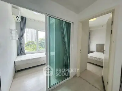 Modern apartment with two bedrooms and large windows offering city views, featuring sleek design and natural light.