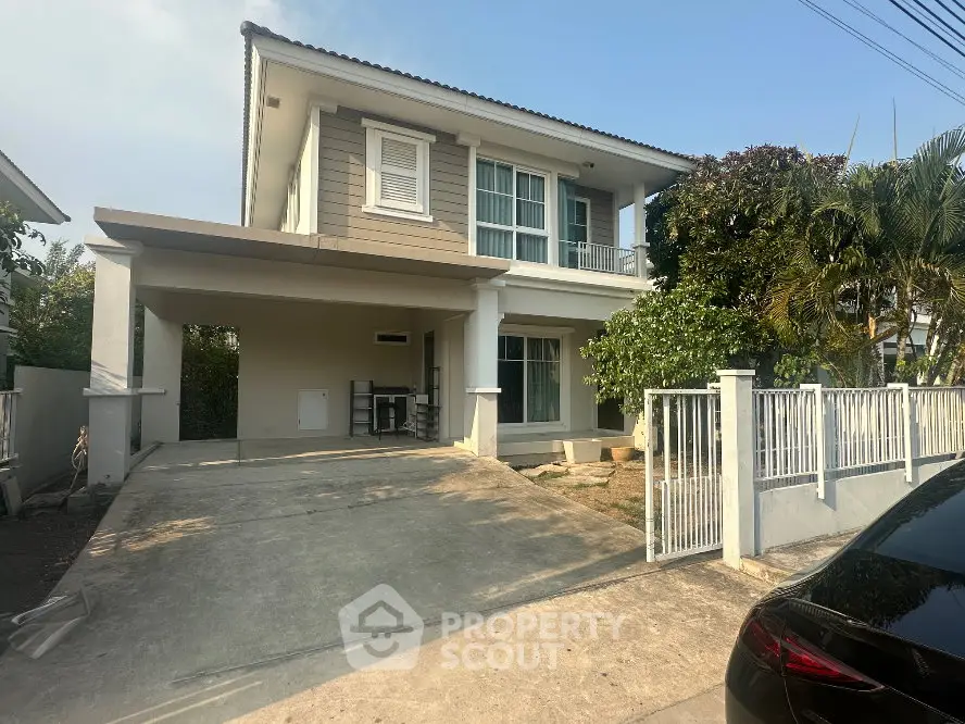 Modern two-story house with driveway and lush greenery in a serene neighborhood.