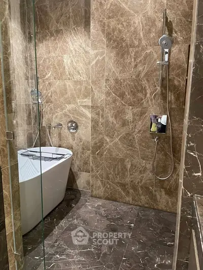 Luxurious marble bathroom with modern freestanding bathtub and sleek shower fixtures.