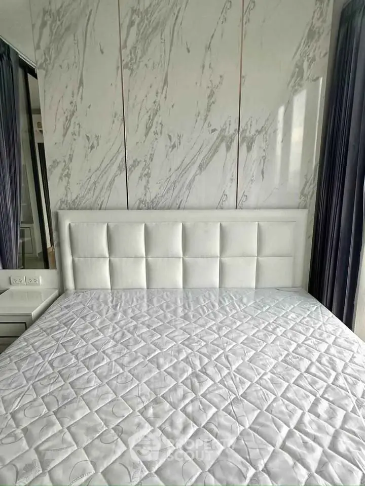 Luxurious bedroom with elegant marble accent wall and plush white headboard