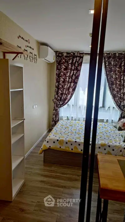 Cozy bedroom with stylish decor and large window for natural light