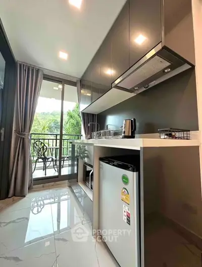 Modern kitchen with sleek cabinetry and balcony view