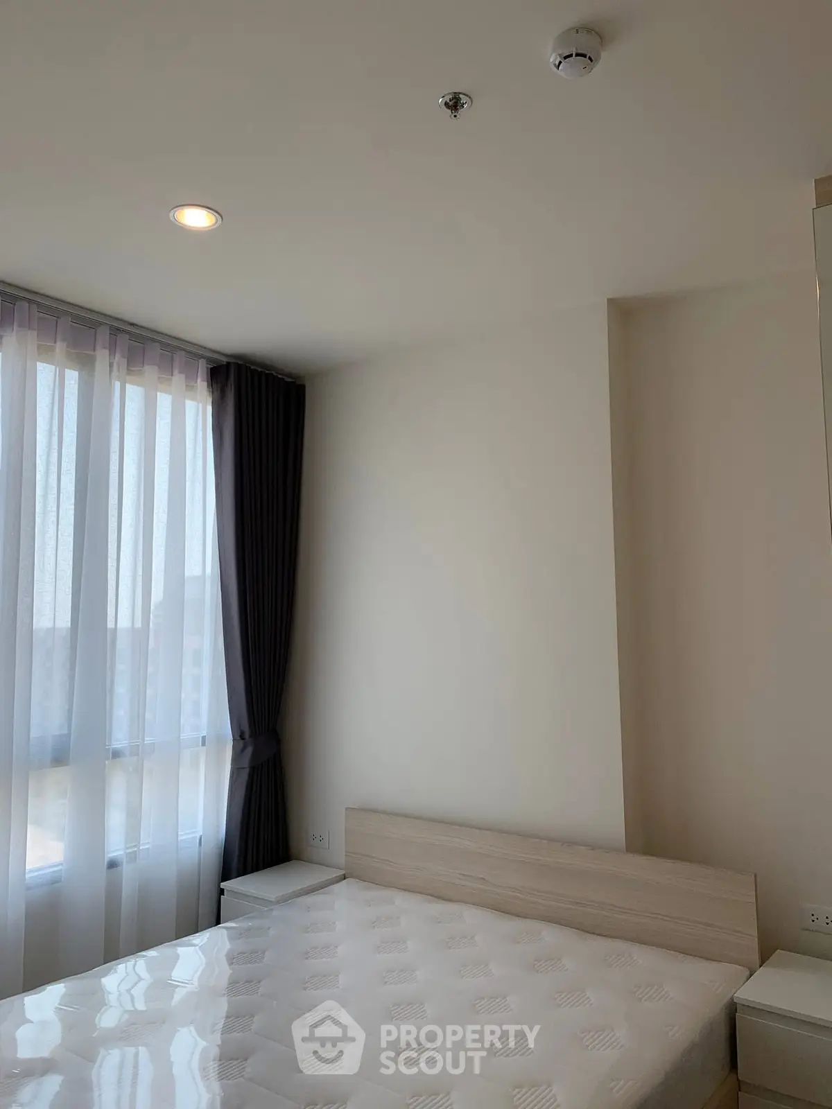 Bright and cozy bedroom with large window and modern furnishings