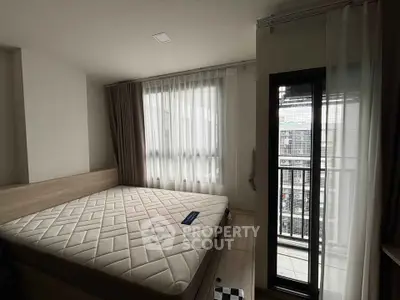 Cozy bedroom with large window and balcony access in modern apartment