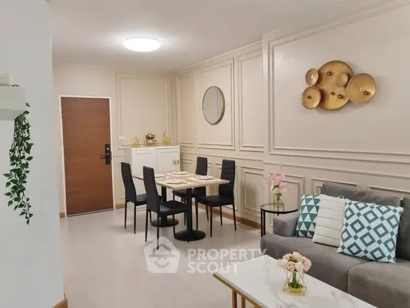 Elegant living room with modern decor and dining area, featuring stylish wall art and cozy seating.