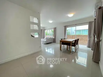 Spacious open-plan living and dining area with large windows and modern decor.