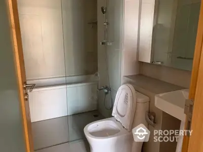 Modern bathroom with glass shower and sleek fixtures in a contemporary home.