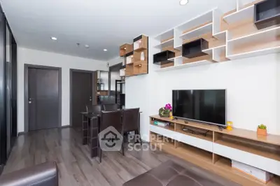 Modern living room with stylish shelving and flat-screen TV, featuring sleek wooden flooring and contemporary furniture.