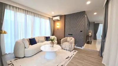 Modern living room with elegant decor, featuring a cozy sofa and stylish armchair, perfect for relaxation.