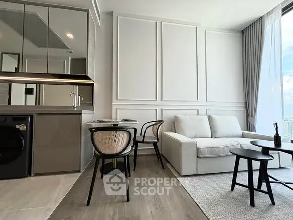 Modern living room with sleek furniture and large windows offering natural light.