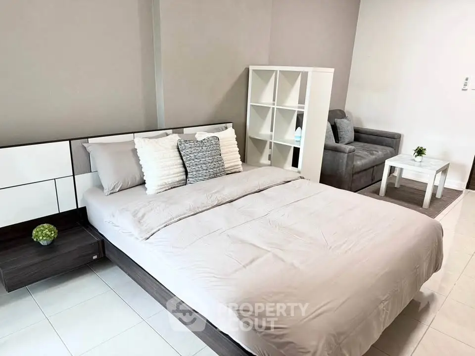 Modern bedroom with stylish decor and cozy seating area, perfect for relaxation and comfort.
