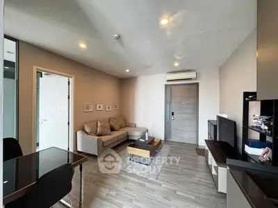 Modern living room with sleek furniture and neutral tones, featuring a cozy sofa and stylish decor.