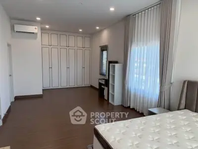 Spacious bedroom with elegant curtains and ample storage in modern home