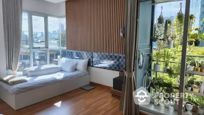 Modern bedroom with large windows and balcony garden offering stunning city views.