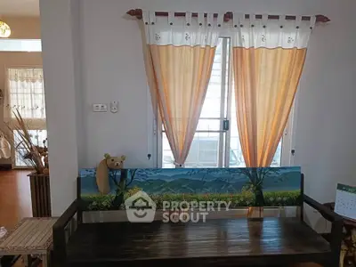 Charming living room with wooden bench and scenic window view, perfect for relaxation.