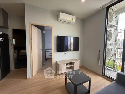 Modern living room with sleek design, featuring a wall-mounted TV and large window with city view.