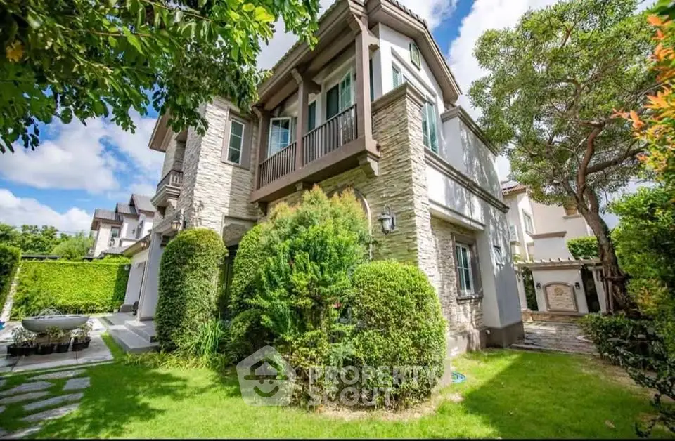 Charming two-story house with lush garden and elegant stone facade in a serene neighborhood.