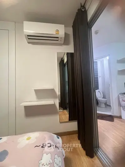 Cozy bedroom with air conditioning and ensuite bathroom in modern apartment.