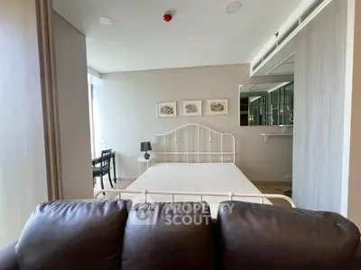 Modern bedroom with stylish decor and large window offering natural light.