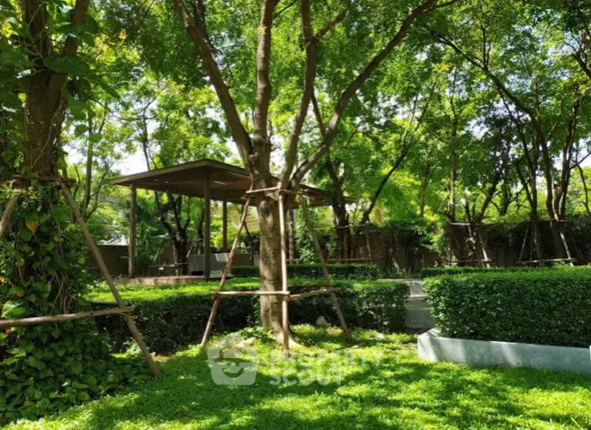 Lush green garden with trees and hedges in a serene outdoor setting.