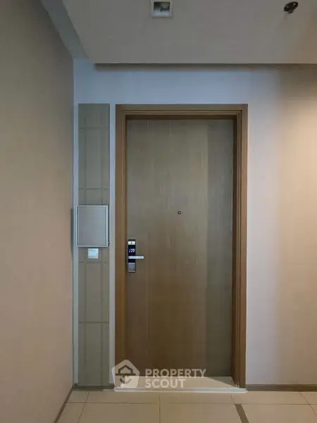Modern apartment entrance with sleek wooden door and digital lock