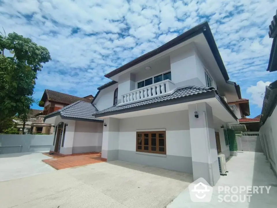 Stunning two-story house with modern design and spacious driveway under a clear blue sky.