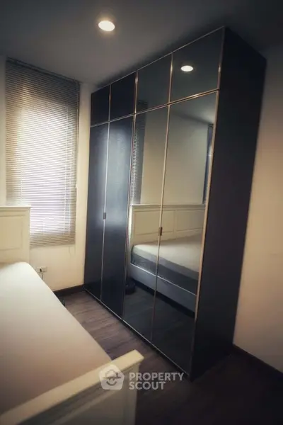 Modern bedroom with sleek mirrored wardrobe and cozy lighting