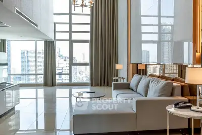 Luxurious high-rise living room with floor-to-ceiling windows and stunning city views.