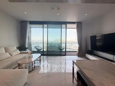 Luxurious living room with stunning city and water views, featuring elegant furniture and floor-to-ceiling windows.