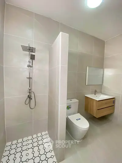 Modern bathroom with sleek shower and elegant vanity in a contemporary home.