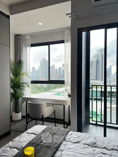 Modern bedroom with city view, featuring a study desk by the window and a cozy balcony.