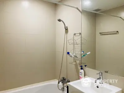 Pristine bathroom with a full-sized tub, modern fixtures, and neutral tiles, perfect for a relaxing soak after a long day.