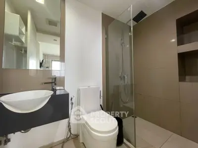Modern bathroom with sleek design featuring glass shower and stylish sink.