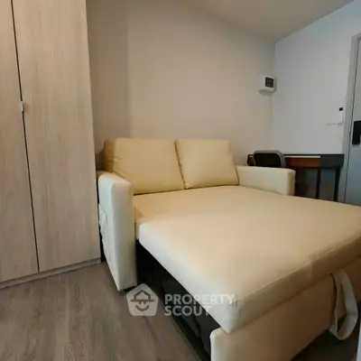 Cozy living room with beige sofa bed and wooden wardrobe