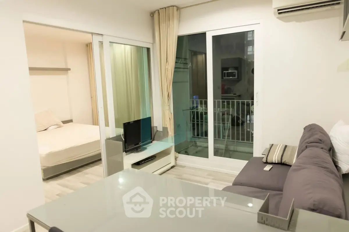 Modern apartment interior with cozy living room and bedroom, featuring a small balcony and stylish decor.