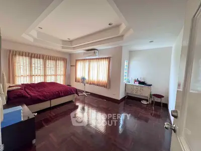 Spacious bedroom with elegant wooden flooring and natural light