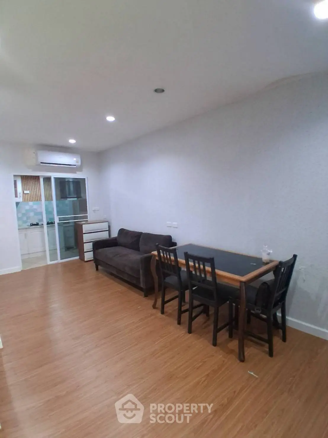 Spacious living room with modern furniture and wooden flooring in a stylish apartment.