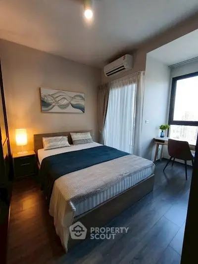 Modern bedroom with stylish decor and natural light, featuring a cozy bed and work desk.