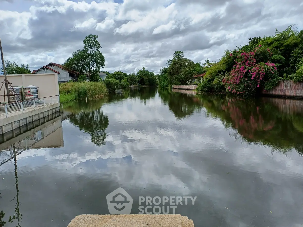 Scenic waterfront view with lush greenery and serene reflections, perfect for tranquil living.