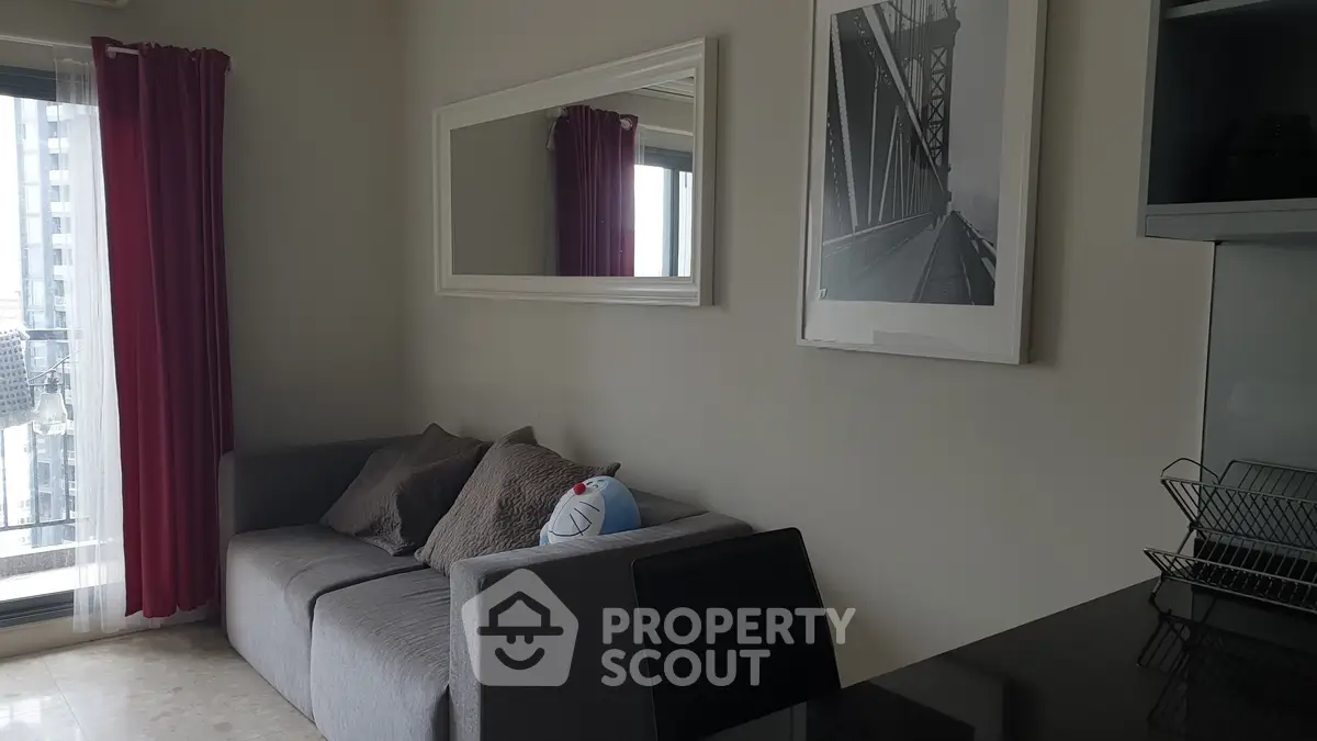 Modern living room with stylish decor and large window view in urban apartment.