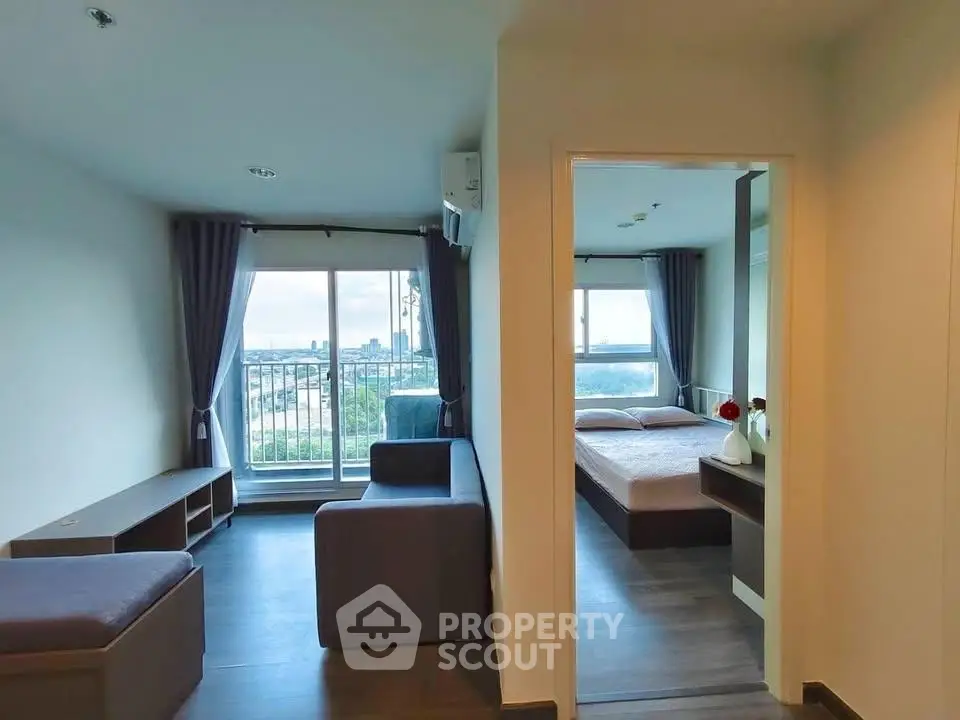 Modern apartment with spacious living room and bedroom, featuring large windows and a balcony with city views.