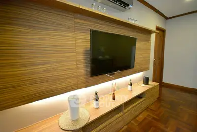 Modern living room with stylish wooden TV wall unit and parquet flooring