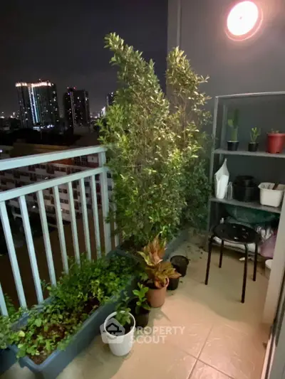 Charming balcony with lush plants and city skyline view at night