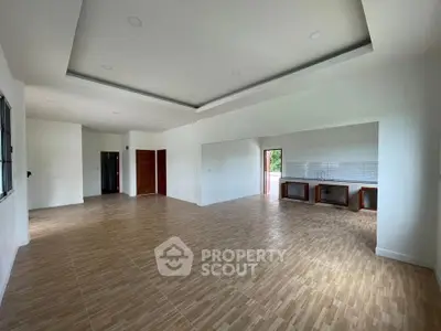 Spacious open-plan living area with modern kitchen and wooden flooring