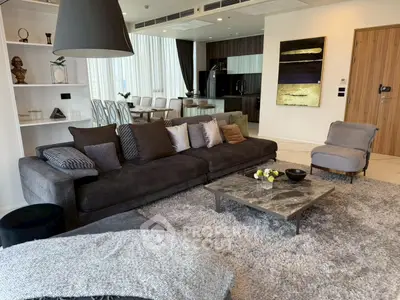 Luxurious modern living room with plush sofa, stylish decor, and open kitchen layout in a high-end apartment.