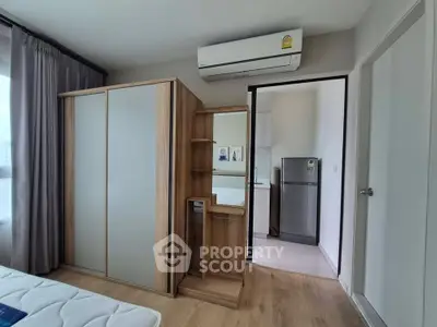 Modern bedroom with wooden wardrobe and air conditioning in a stylish apartment.